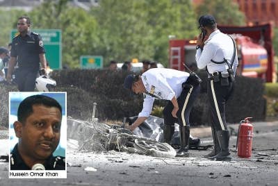 Anggota polis memeriksa sebuah motosikal yang terbakar di lokasi kejadian pesawat terhempas di Bandar Elmina dekat sini pada Khamis - Foto: Bernama