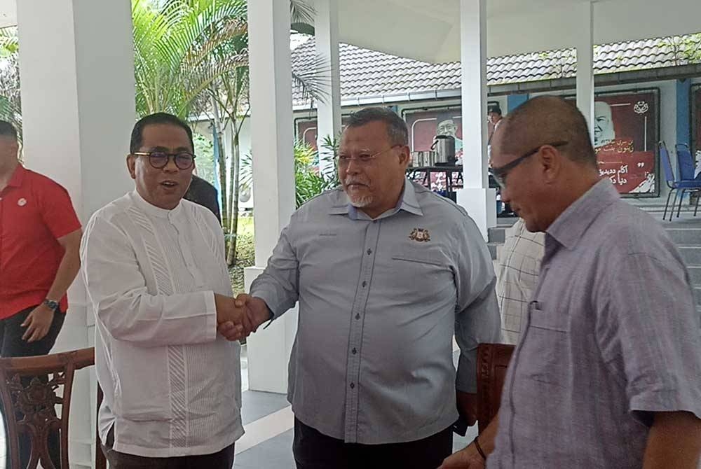 Mohamed Khaled (kiri) bersalaman dengan Aminolhuda di Ibu Pejabat UMNO Johor pada Jumaat.