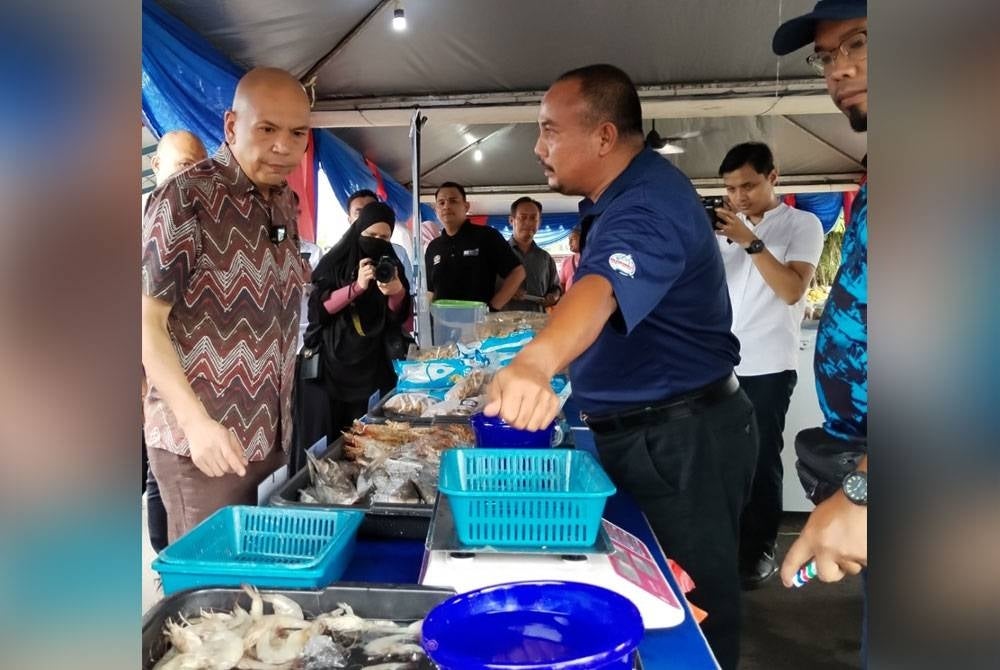 Amirzan meninjau jualan barangan basah pada program berkenaan.