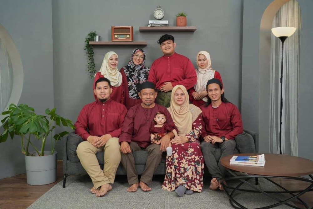 Arwah Muhammad Hafiz (duduk, kanan) bergambar sekeluarga ketika perayaan Hari Raya Aidilfitri, tahun lalu. 