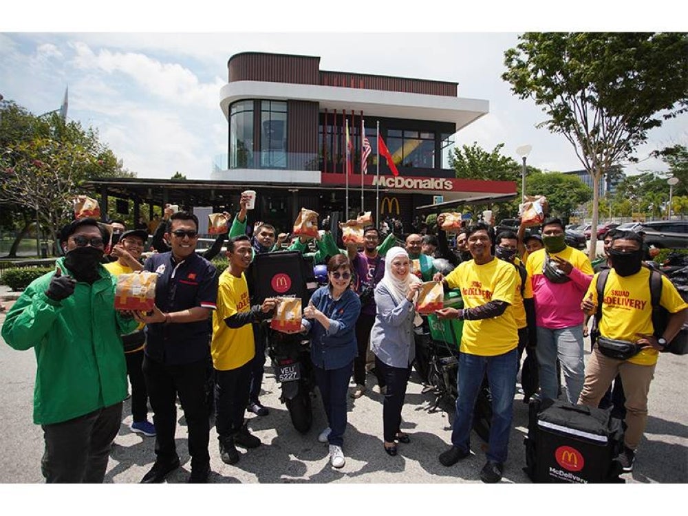 Melati, Felina serta Zaid (dua dari kiri) bersama ‘riders’ yang menebus set hidangan percuma semasa program Mekdi Belanja Rider.