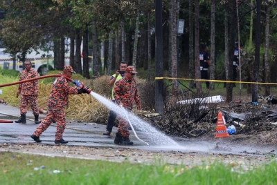 Anggota pasukan Bomba Dan Penyelamat membersihkan kesan kebakaran di kawasan nahas pesawat terhempas, pada Jumaat. - Foto Bernama