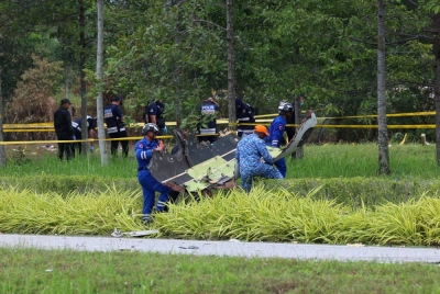 Anggota pasukan keselamatan mengangkat serpihan pesawat di kawasan nahas pesawat terhempas pada Jumaat. - Foto Bernama