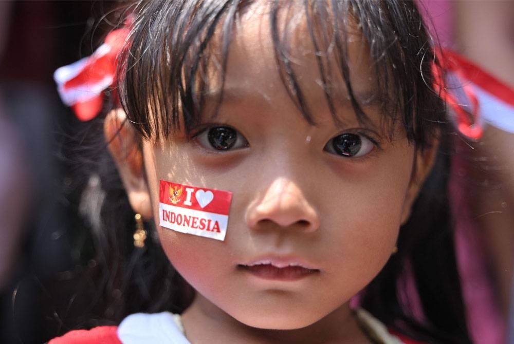 Seorang kanak-kanak perempuan menyertai sambutan Hari Kemerdekaan komuniti tempatan di Jakarta.