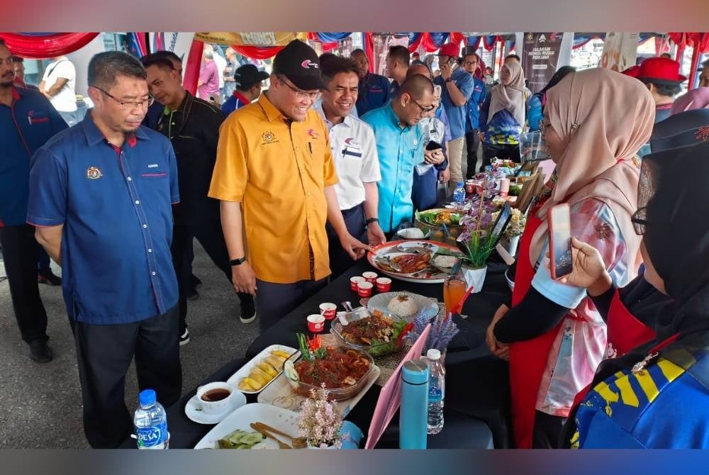 Adnan melihat juadah yang dimasak oleh peserta pada Program Jelajah Perikanan 'Rasa-Rasa Akuakultur' negeri Pahang di pekarangan bangunan Majlis Amanah Rakyat (Mara) pada Sabtu.