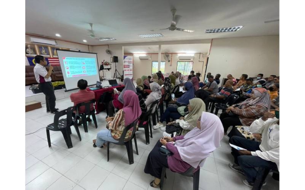 Petugas memberi taklimat kepada para penduduk dalam Sesi Taklimat Skim Perubatan MADANI di Dewan Kompleks Penghulu Mukim Hulu Kinta, Perak.