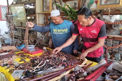 Ahmad Lokman (kiri) menunjukkan tasbih daripada kayu yang dihasilkan di Pusat Herba dan Kraf Melawi, 1001 Rahsia Khazanah Rimba pada Jumaat.