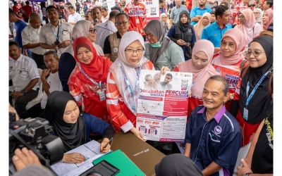 Menteri Kesihatan, Dr Zaliha Mustafa (tengah) menunjukkan poster maklumat Skim Perubatan MADANI kepada penduduk semasa hadir di majlis pelancaran program MADANI Afiat di Kedah.