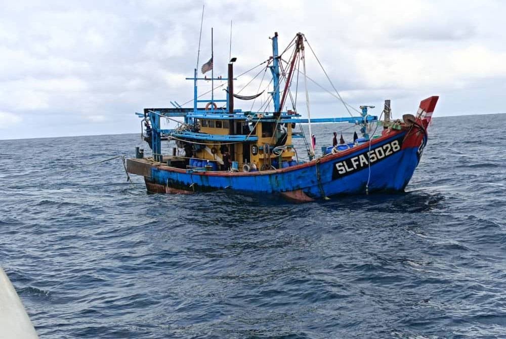 Sebuah bot nelayan tempatan ditahan selepas didapati menjalankan aktiviti perikanan menggunakan pukat tunda kurang dari 8 batu nautika di Kepulauan Sembilan, Pulau Pangkor pada Sabtu. - Foto: Jabatan Perikanan Perak