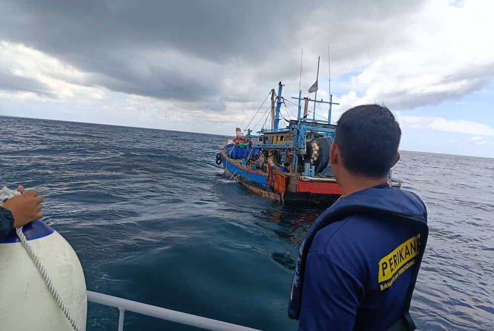 Pegawai Jabatan Perikanan yang menjalankan rondaan menahan sebuah bot pukat tunda di Kepulauan Sembilan, Pulau Pangkor. - Foto: Jabatan Perikanan Perak