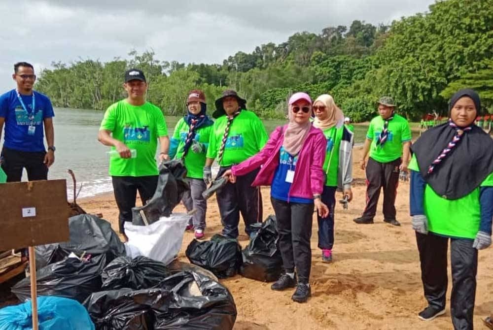 Mohamad Halim (dua dari kiri) menunjukkan longgokan sampah yang dikumpul sempena aktiviti pembersihan di Pantai Cermin, Port Dickson pada Ahad.