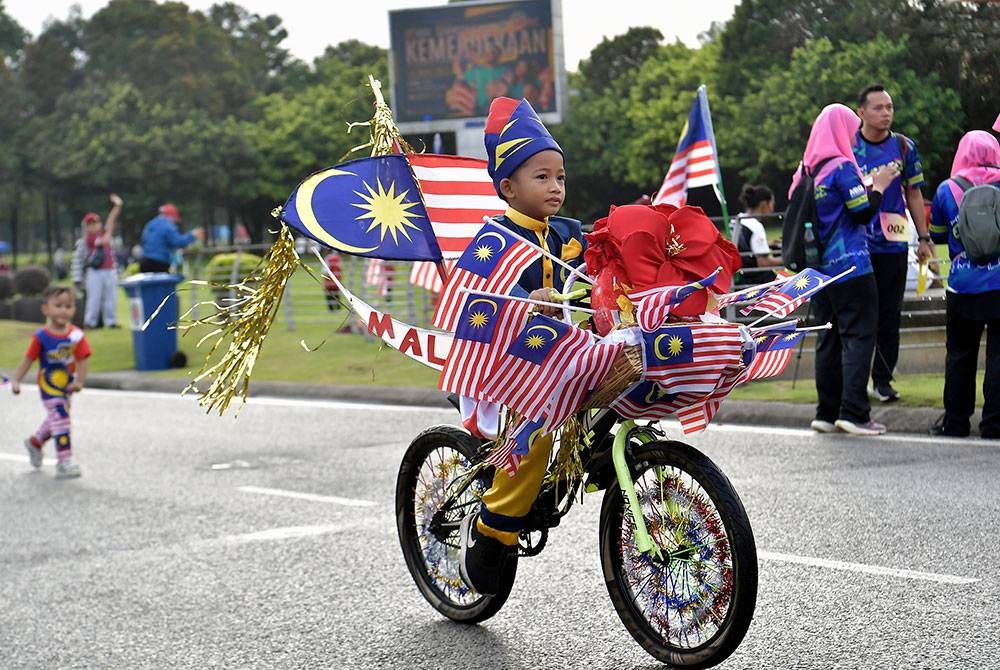 Zulfahmi Romaden Zulazmi, 8, memperagakan basikalnya yang dihiasi dengan Jalur Gemilang sempena menyambut bulan kebangsaan semasa turut serta dalam Program Shah Alam Hari Tanpa Kenderaan dan CEO Run 2023 di Dataran Kemerdekaan Shah Alam hari ini.