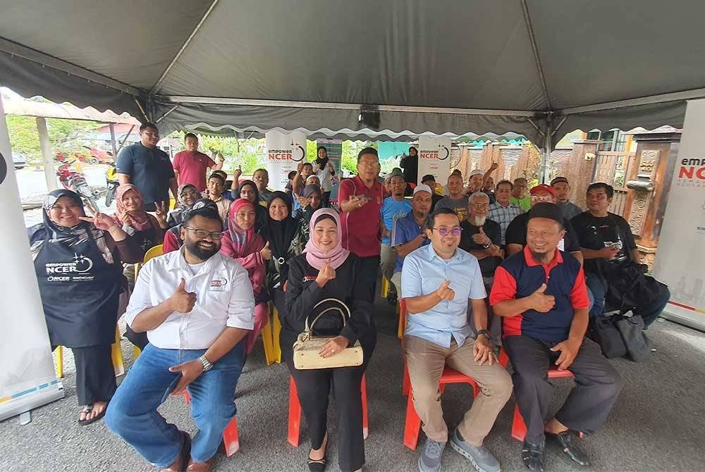 Hanita (duduk, dua dari kiri) dan Muhamad Syukor (duduk, dua dari kanan) bersama peserta dan penduduk yang terlibat dalam program Khidmat Bakti empowerNCER Seberang Perai Tengah bersama komuniti.