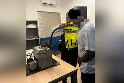 Salah seorang individu menjalankan ujian nafas dengan menggunakan alat EBA II dalam Operasi Mabuk di Jalan Pandan Utama, Ampang pada Sabtu.