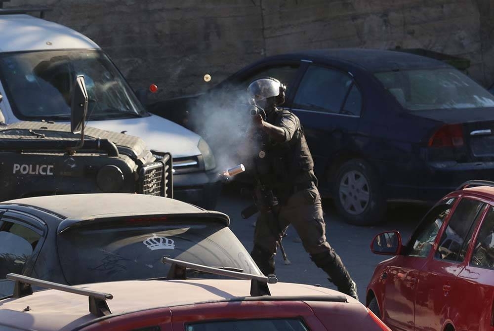 Seorang anggota polis sempadan Israel melepaskan tembakan gas pemedih mata ke arah penunjuk perasaan Palestin semasa pertempuran berikutan serbuan Israel di kampung Beita berhampiran bandar Nablus di Tebing Barat. Foto Xinhua
