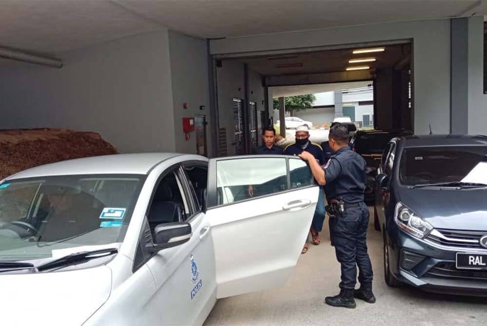 Tertuduh (dua dari kiri) diiringi anggota polis sebaik selesai keputusan kes pada Selasa.