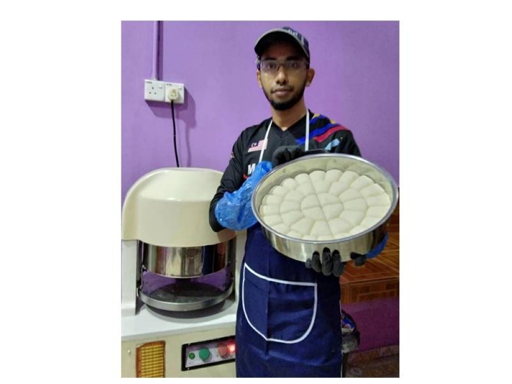 Khairul menunjukkan doh roti canai yang siap diuli dan akan disejukbekukan.