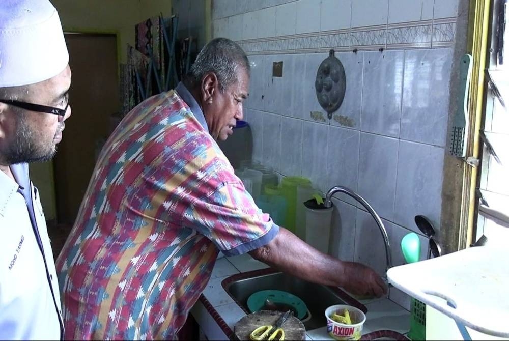 
Mohd Tarmizi melihat tiada air keluar daripada paip ketika Ampandi membuka paip dirumahnya pada Selasa