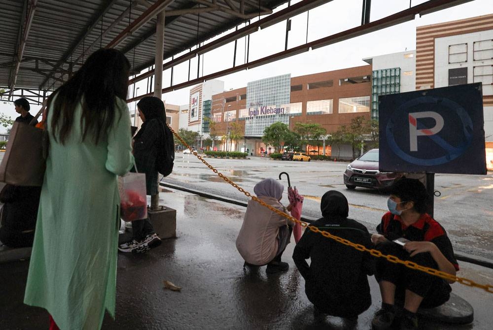 Orang ramai menunggu di luar bangunan pusat beli-belah di AEON Klebang dipercayai susulan panggilan ancaman bom. - Bernama