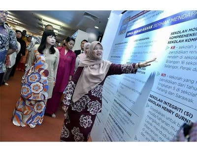 Fadhlina menunjukkan maklumat mengenai pencapaian semasa PPPM sambil diperhatikan Timbalan Menteri Pendidikan, Lim Hui Ying (kiri) ketika majlis pelancaran Laporan Tahunan 2022 PPPM di Perpustakaan Raja Tun Uda, Shah Alam pada Selasa.