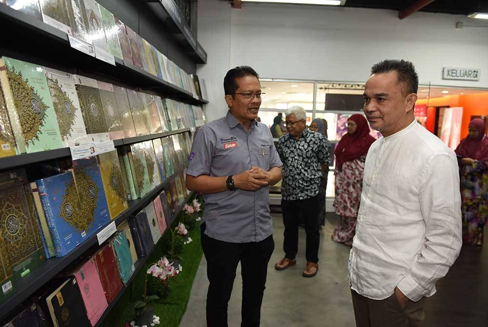 Ahmad Yani (kiri) memberi penerangan kepada Ahmad Farid (kanan) mengenai al-Quran yang diterbitkan oleh Karangkraf.