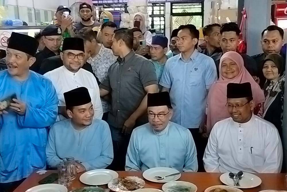 Anwar ( tengah) makan tengah hari bersama Suhaizan (kanan) Dan Onn Hafiz (kanan) di medan selera Taman Cempaka Kempas pada Jumaat.