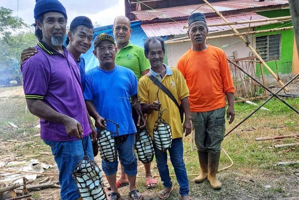 Penduduk kampung menunjukkan ubi yang telah dimasukkan ke dalam jut.