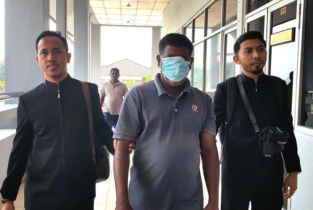 Tertuduh (tengah) diiringi pegawai SPRM di Mahkamah Sesyen Seremban pada Isnin.