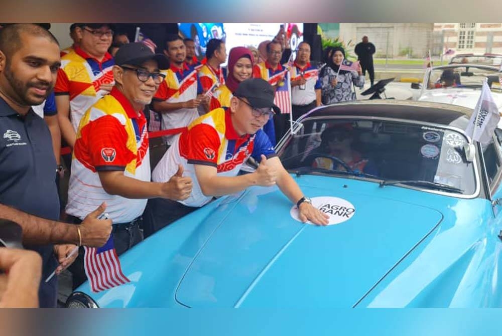 Foong Hinn diiringi Tengku Ahmad Badli menampal pelekat logo Agrobank pada pelancaran flag off dan perasmian perarakan kontinjen Kereta Antik Agrobank di Menara Agro Bank Jalan Lebuh Pasar di Kuala Lumpur pada Isnin.