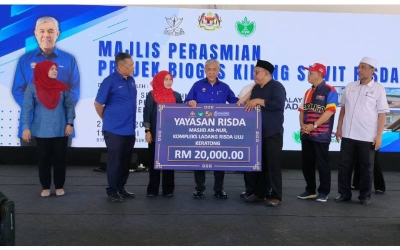 Timbalan Perdana Menteri, Datuk Seri Dr Ahmad Zahid Hamidi menyampaikan sumbangan Yayasan RISDA kepada wakil Masjid An-Nur sempena majlis perasmian Projek Biogas Kilang Sawit RISDA Ulu Keratong pada Ahad. 