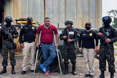 Wilmer Manolo Wood (tiga dari kiri), dikawal oleh anggota ATIC dan PMOP selepas ditangkap di La Ceiba, Honduras pada Ahad. - Foto ATIC / AFP