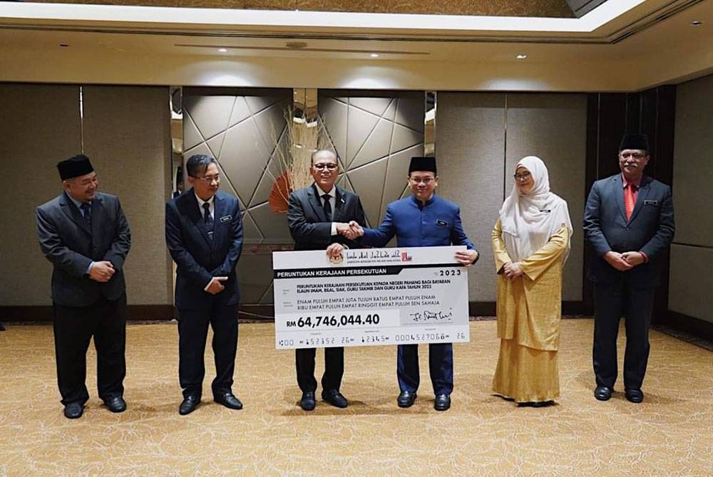 Wan Rosdy (tiga dari kiri) menerima cek peruntukan bayaran elaun imam, bilal, siak, guru takmir, dan guru KAFA bagi tahun 2023 yang disampaikan Mohd Na'im dalam satu majlis di Kuala Lumpur pada Selasa. Foto Fb Wan Rosdy Wan Ismail