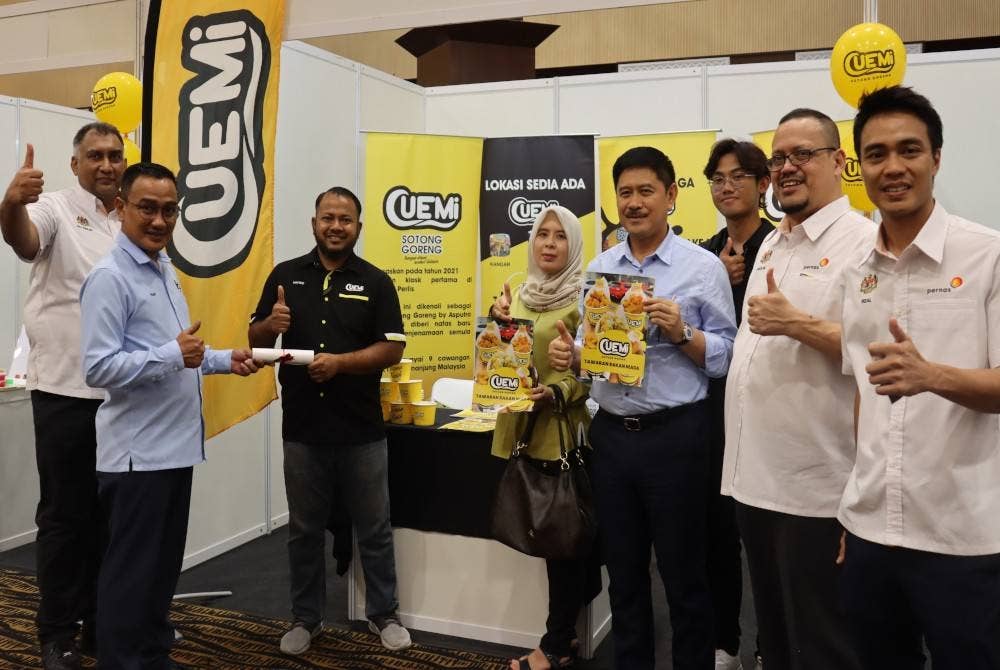 Ahmad Fuad (dua dari kiri) menyampaikan sijil penyertaan kepada usahawan terlibat.