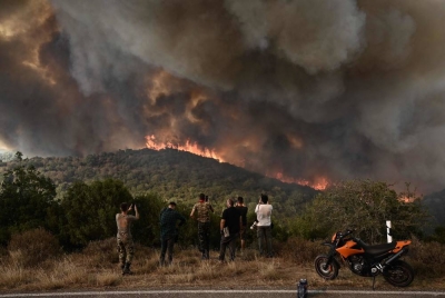 Orang ramai melihat kebakaran hutan yang marak di hutan di Sikorahi, dekat Alexandroupoli, utara Greece pada Rabu. - Foto AFP