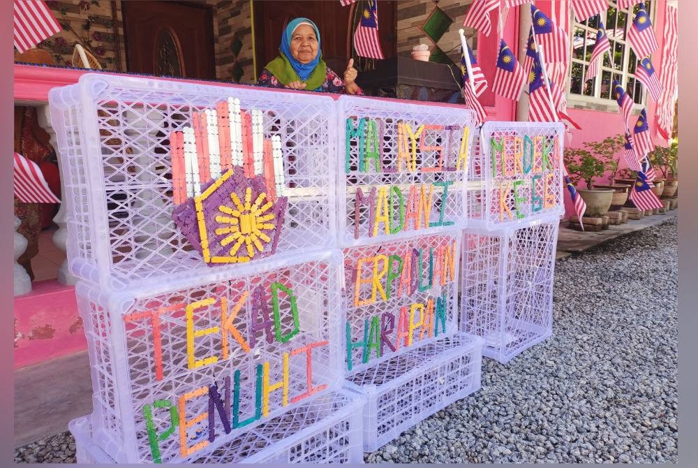 
Fatimah Abd Kadir, 78, menunjukkan hiasan daripada bakul terpakai di hadapan rumahnya di Kampung Chulek sempena program Halaman Rumah Merdeka.
