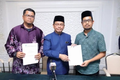 Presiden ABIM, Muhammad Faisal Abdul Aziz (kanan) menyerahkan memorandum kepada Menteri di Jabatan Perdana Menteri (Hal Ehwal Agama), Datuk Dr Mohd Na'im Mokhtar.