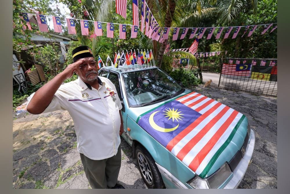 Fatahalmubil memasang lebih 200 Jalur Gemilang pada Proton Iswara. - Foto Bernama