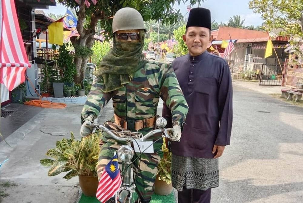 Amran bersama patung tentera berbasikal.