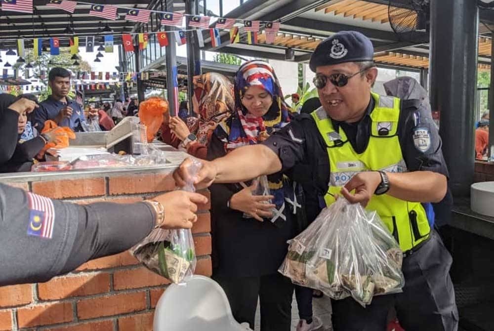 Pengagihan nasi lemak percuma kepada pengguna diadakan untuk memeriahkan sambutan kemerdekaan. - Foto Prolintas jalan raya sempena Hari Kebangsaan ke-66