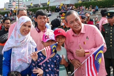 Aminuddin (kanan) berkesempatan beramah mesra dengan orang ramai pada sambutan tersebut pada Khamis.