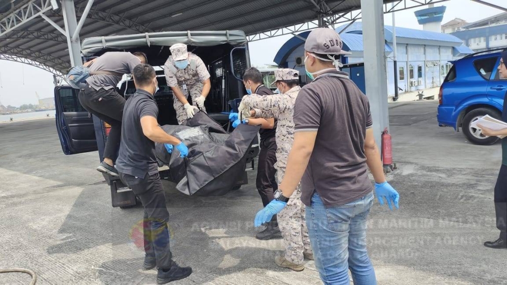 Mayat kru kapal Eco Galaxy dibawa masuk ke dalam kenderaan polis bagi proses siasatan seterusnya setelah terjatuh ke dalam laut di Perairan Pintu Gedung Tengah, Klang, Selangor pada Selasa.