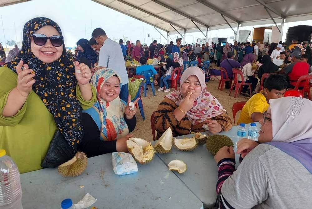 Norzaidah (depan, kanan) bersama keluarganya yang datang bercuti ke Terengganu sejak Rabu lepas tidak melepaskan peluang untuk menikmati durian Terengganu.