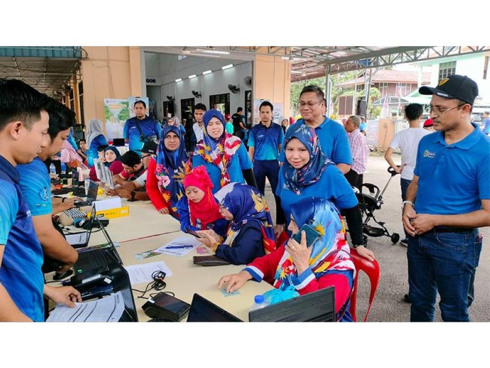 Norliza (dua dari kanan) dan Ahmad Dasuki (kanan) ketika meninjau gerai pameran yang dibuka sempena Karnival Semarak Kasih Merdeka PTPTN.