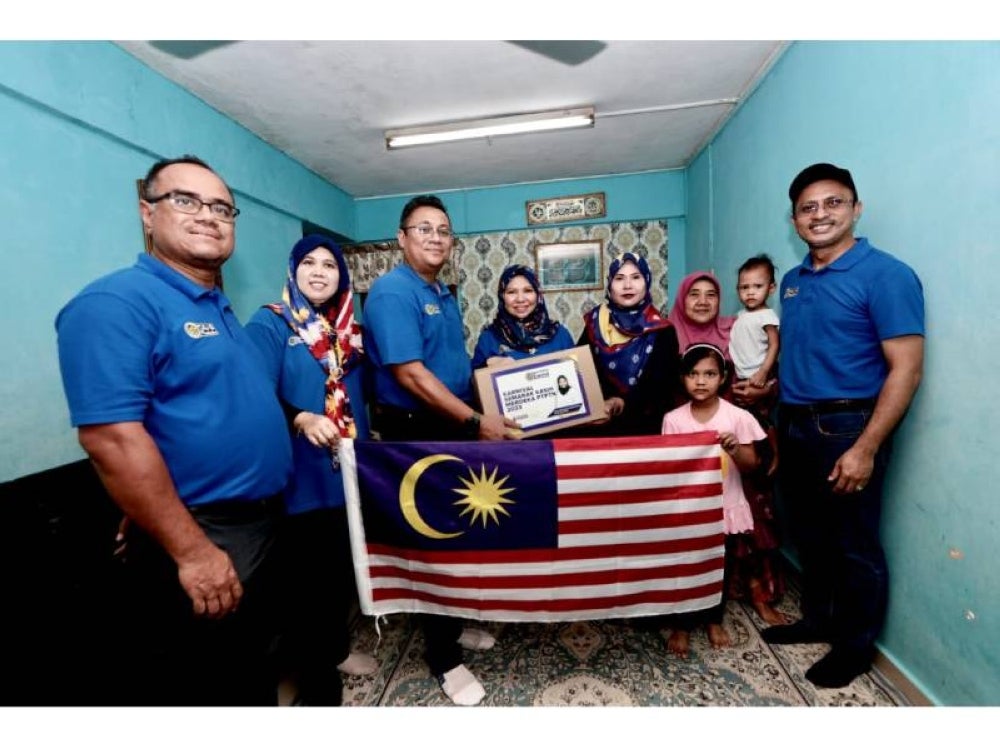 Norliza (empat dari kiri) menyampaikan bakul makanan kepada salah seorang penerima.