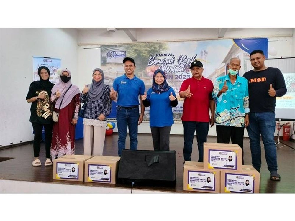 Norliza (empat dari kanan) bergambar bersama penerima penerima bakul makanan yang disediakan sempena Karnival Semarak Kasih Merdeka PTPTN.
