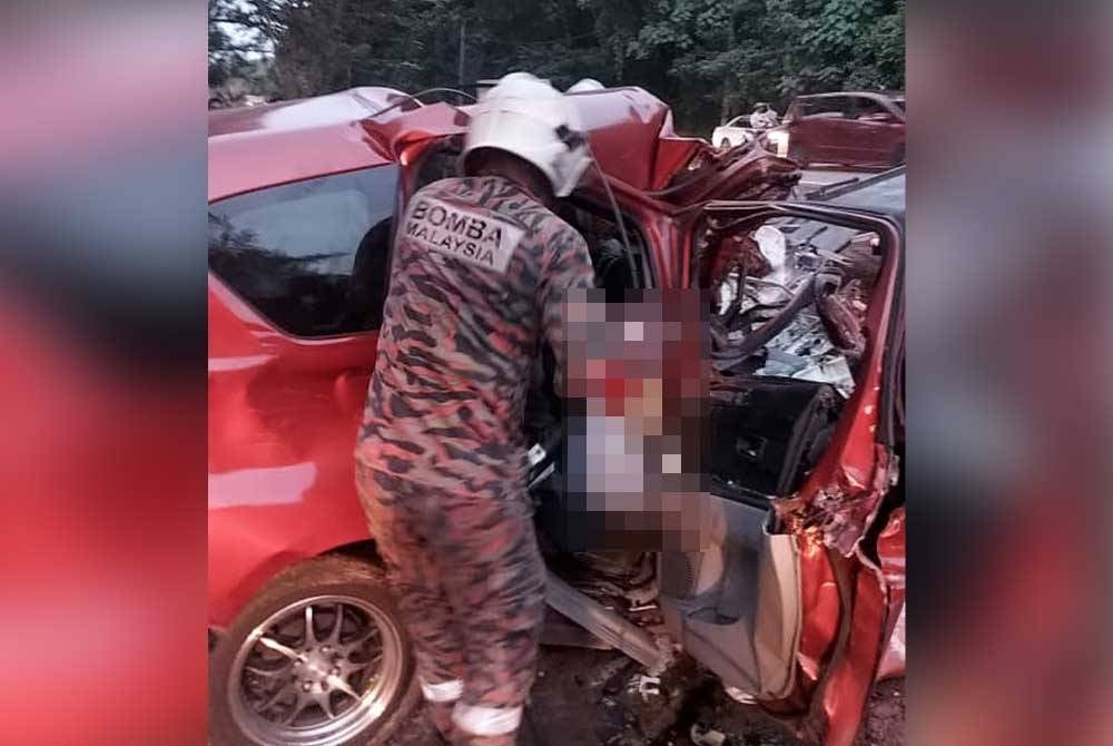 Anggota bomba berusaha mengeluarkan mangsa yang tersepit.