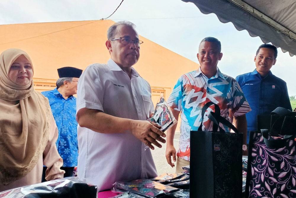 Abdul Fattah (dua dari kiri) meninjau ruang pameran disediakan sempena Karnival Usahawan Kami Anak Felda (KAF) Wilayah Trolak di Felda Trolak Utara dekat Sungkai pada Jumaat.