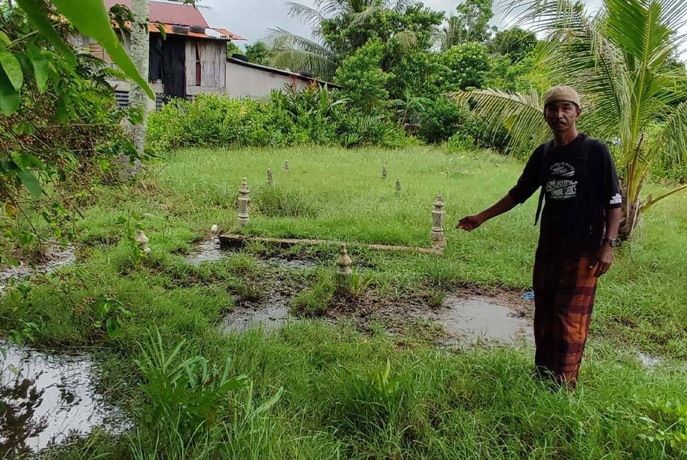 Penduduk, Kamaruddin Saad menunjukkan keadaan air yang bergenang di sesetengah kawasan tanah perkuburan lama berhampiran pelantar Kampung Seberang Kota.