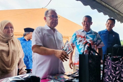 Abdul Fattah (dua dari kiri) meninjau ruang pameran disediakan sempena Karnival Usahawan Kami Anak Felda (KAF) Wilayah Trolak di Felda Trolak Utara dekat Sungkai pada Jumaat.