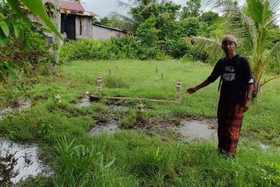 Penduduk, Kamaruddin Saad menunjukkan keadaan air yang bergenang di sesetengah kawasan tanah perkuburan lama berhampiran pelantar Kampung Seberang Kota.